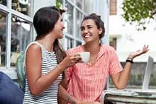 Deux amies discutent à la terrace d'un café.