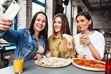 Trois amies au restaurant prennent un selfie